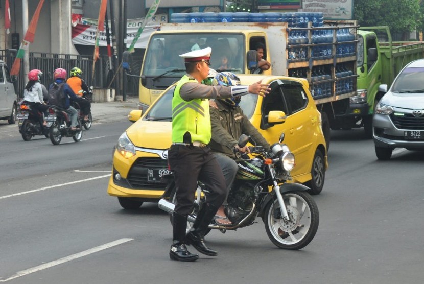 Polisi mengadang pengendara sepeda motor yang melanggar lalu lintas (ilustrasi).