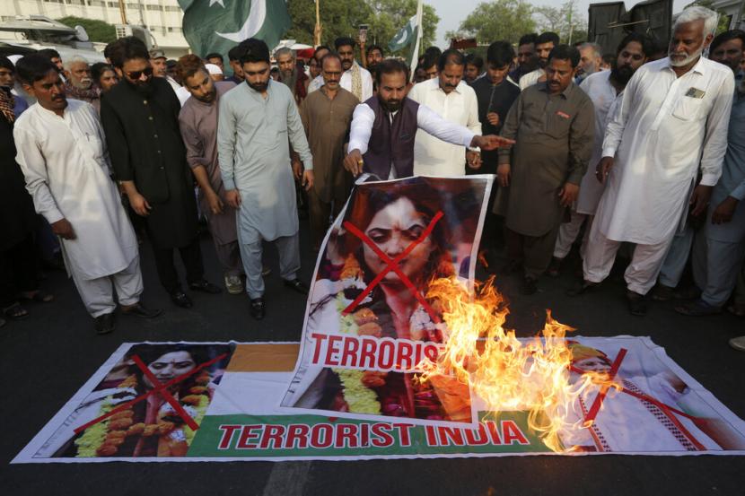 Anggota serikat pengemudi becak membakar representasi bendera nasional India dan gambar Nupur Sharma, juru bicara partai nasionalis Hindu yang berkuasa, selama demonstrasi untuk mengutuk referensi menghina Islam dan Nabi Muhammad yang dibuat baru-baru ini oleh Sharma, di Karachi , Pakistan, Selasa, 6 Juni 2022.