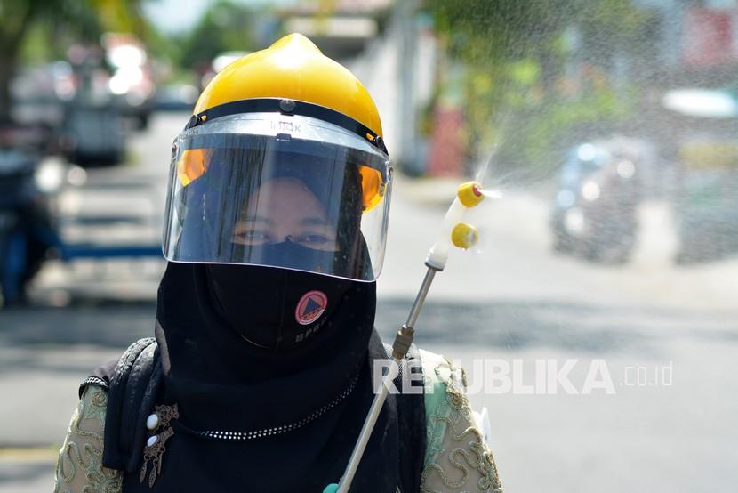 Anggota Srikandi Kelompok Siaga Bencana (KSB) Kota Padang menyempotkan disinfektan ke fasilitas umum di Batang Arau, Padang, Sumatera Barat, Rabu (21/4/2021). (ilustrasi)