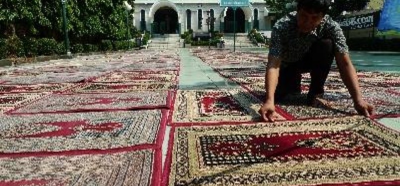 Anggota takmir masjid Sunda Kelapa tengah membersihkan karpet untuk pelaksanaan shalat Tarawih. 