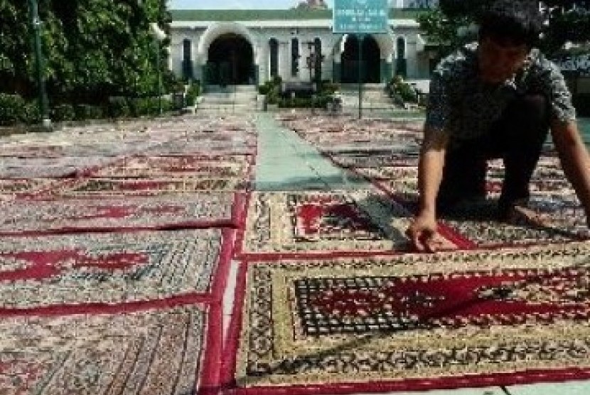 Anggota takmir masjid Sunda Kelapa tengah membersihkan karpet untuk pelaksanaan shalat Tarawih. 