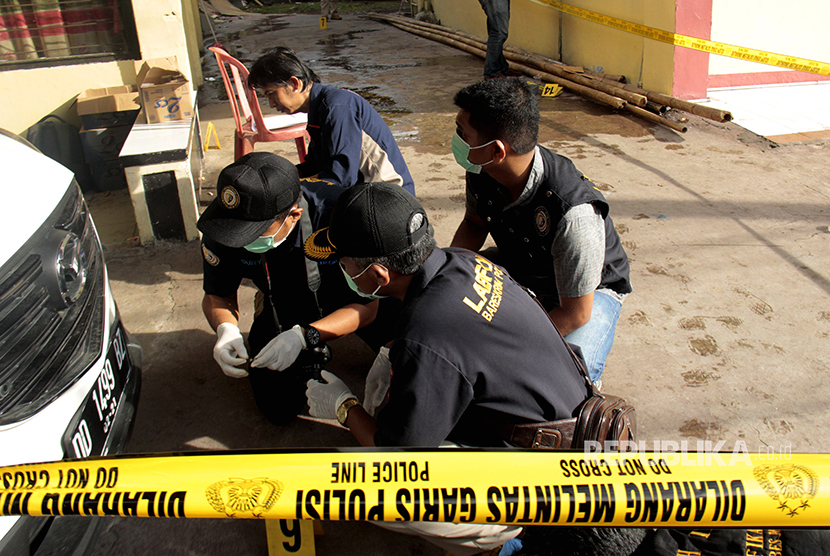 Anggota Tim Laboratorium Forensik (Labfor) Polda Sulsel melakukan olah Tempat Kejadian Perkara (TKP) pasca kejadian pelemparan bom di halaman Polsek Bontoala, Makassar, Sulawesi Selatan, Senin (1/1).