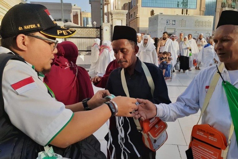 Anggota Tim Pertolongan Pertama Pada Jamaah Haji (P3JH) memberikan masker kepada jamaah haji asal Lombok di Masjid Al Haram, Jumat (19/7). 