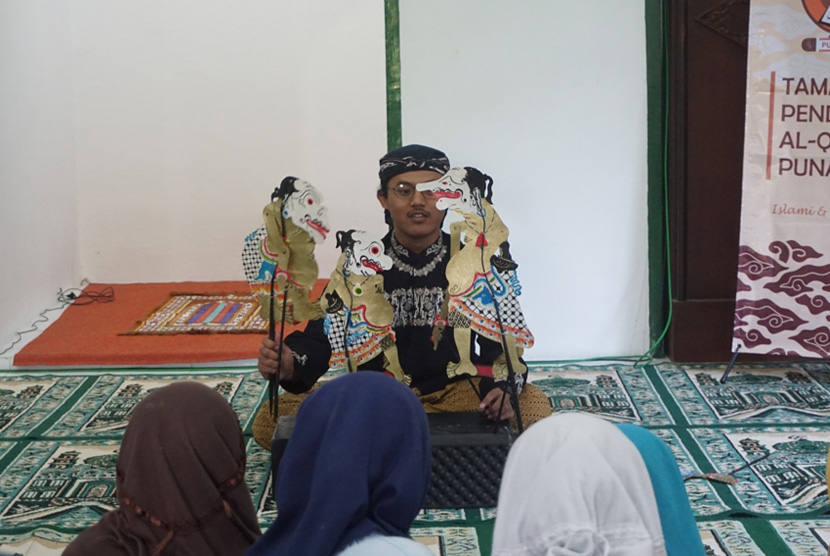  Anggota Tim PKM-M Punakawan UMY memberikan pengajaran  kepada anak-anak TPA di Masjd At Taqwa, Desa Temuwuh Lor, Gamping, Sleman.  Pengajaran ini dilakukan menggunakan media dari wayang.
