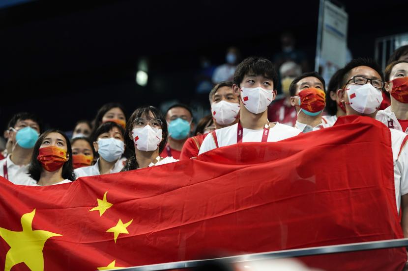 Anggota tim China mendengarkan lagu kebangsaan setelah Shun Wang dari China memenangkan medali emas dalam final gaya ganti individu 200 meter putra di Olimpiade Tokyo 2020, Jumat, 30 Juli 2021, di Tokyo, Jepang. 