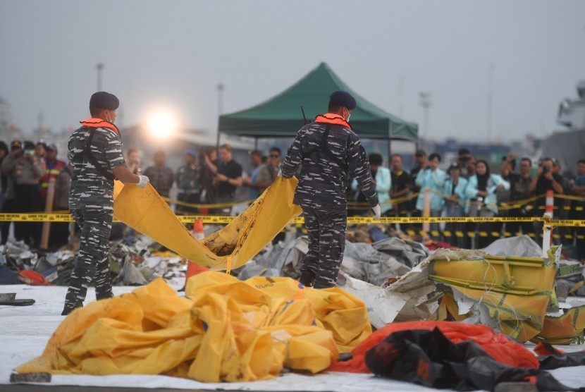 Anggota TNI AL membawa kantung jenazah korban jatuhnya pesawat Lion Air bernomor registrasi PK-LQP dengan nomor penerbangan JT 610 di Pelabuhan Tanjung Priok, Jakarta, Kamis (1/11/2018).