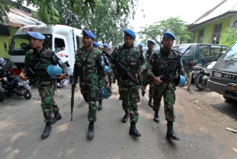 Anggota TNI berjaga di depan Gerbang Pangkalan Utama TNI-AL III saat dilakukan olah TKP di Pelabuhan tanjung Priuk, Jakarta Utara, Kamis (6/3).