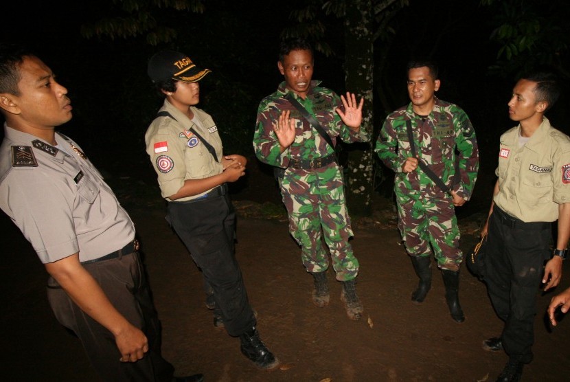 Anggota TNI bersama Taruna Tanggap Bencana (Tagana) dan Polisi berjaga di sekitar daerah longsor Dusun Dlopo, Desa Kepel, Kecamatan Ngetos, Nganjuk, Jawa Timur, Minggu (9/4).