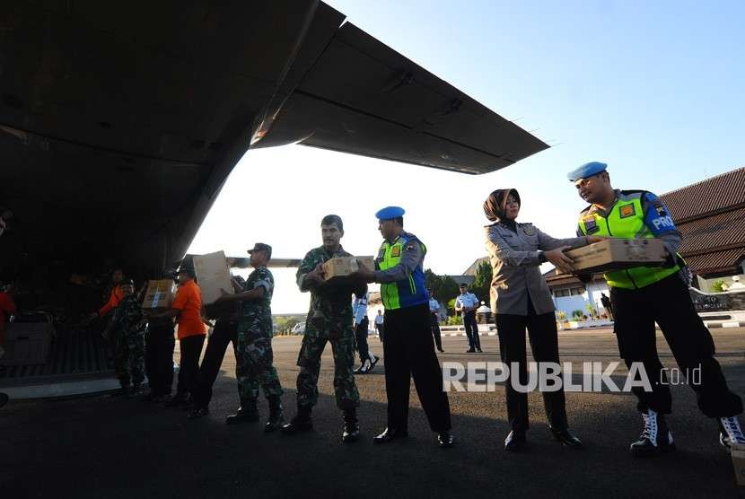 Anggota TNI dan Polri memasukkan bantuan ke dalam pesawat jenis CN-295 di Pangkalan TNI AU Adi Soemarmo, Boyolali, Jawa Tengah, Sabtu (11/8).