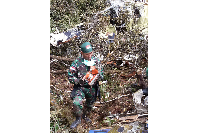 Anggota TNI dari Yonif 133 Sertu Agus Harahap membawa Kotak Hitam (Black Box) pesawat Trigana yang ditemukan di lokasi kecelakaan di Kampung Oksob, Distrik Okbape, Kabupaten Pegunungan Bintang, Papua, Selasa (18/8).