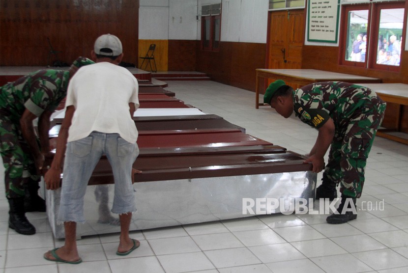 Anggota TNI dibantu warga mempersiapkan peti jenazah untuk korban penembakan Kelompok Kriminal Bersenjata (KKB) di Wamena, Papua, Selasa (4/12/2018). 