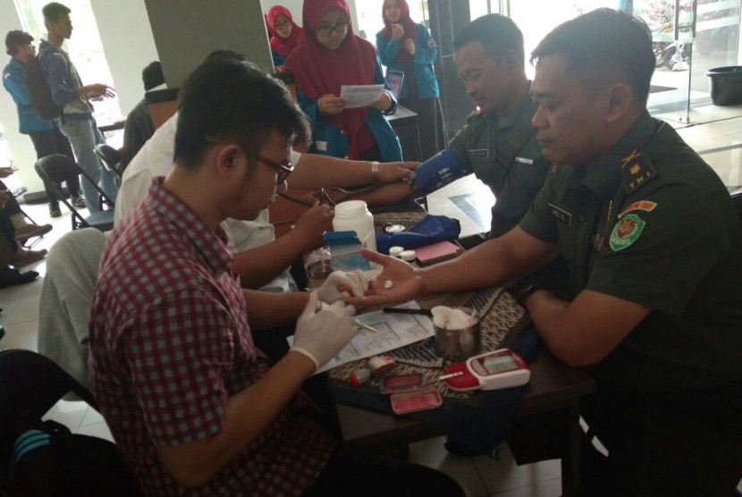 Anggota TNI Korem Badak Putih melakukan pemeriksaan sebagai calon pendonor darah di Aksi Donor Darah AMIK BSI Bogor.      