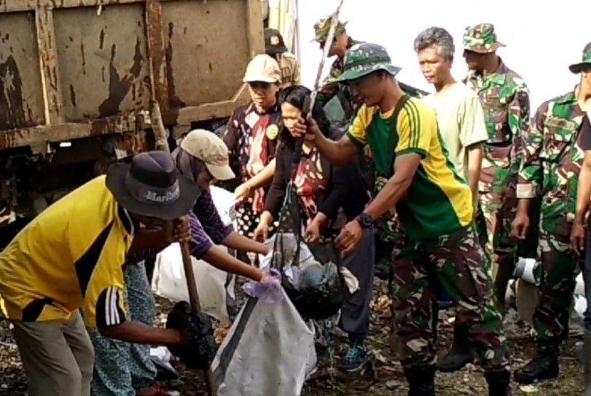 Anggota TNI berbaur dengan warga membersihkan tumpukan sampah (ilustrasi)