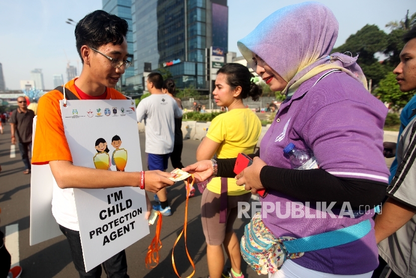Anggota Wahana Visi Indonesia bersama Forum Anak Jakarta membagikan sebanyak 3000 buku saku perlindungan anak bertema 