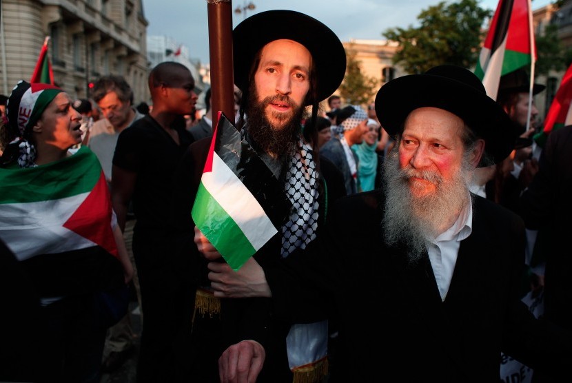 Anggota Yahudi ultra-orthodox, Neturei Karta, kelompok yang menentang zionis dan kependudukan Israel, menggelar aksi menentang serangan Israel ke Gaza di Paris, Prancis, Rabu (23/7).