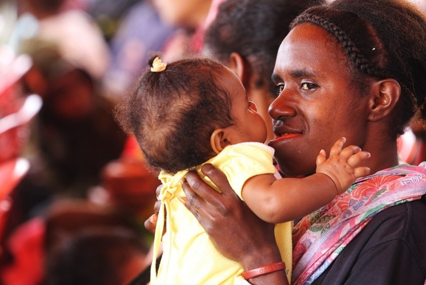 ANGKA KEMATIAN IBU DAN ANAK. Seorang ibu bercanda dengan anaknya sebelum melakukan pemeriksaan kesehatan bayi di Posyandu Kama di Wamena, Kabupaten Jayawijaya, Papua, Kamis (18/4).