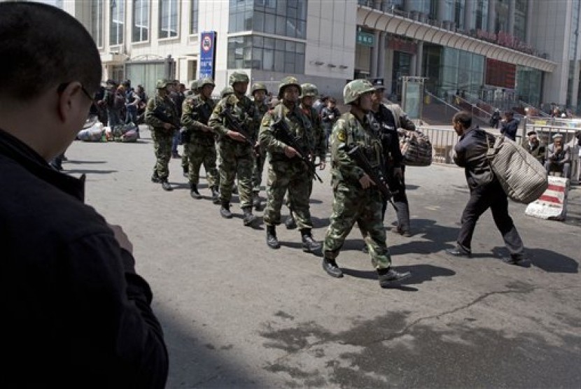 Angkatan bersenjata Cina saat memeriksa area bekas ledakan bom di stasiun kereta api Urumqi, Xinjiang.