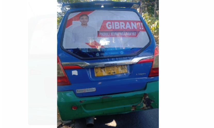 Angkot di Kota Bandung dengan poster Gibran Rakabuming Raka tertempel di kaca bagian belakang.