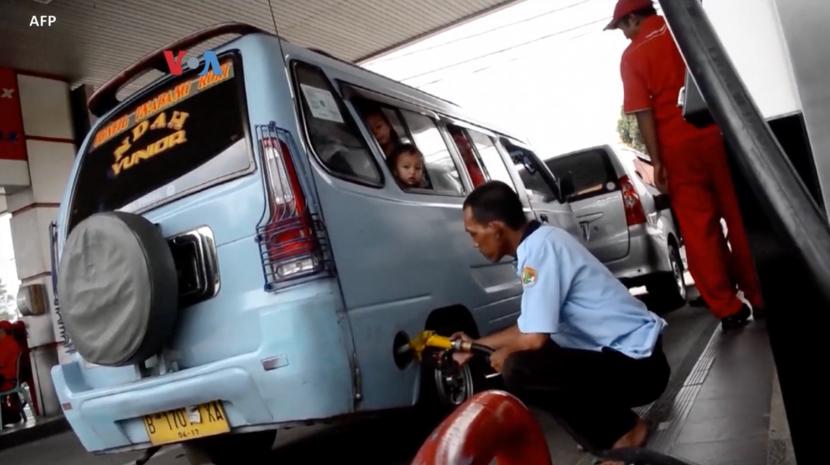 Angkot sedang mengisi bahan bakar.