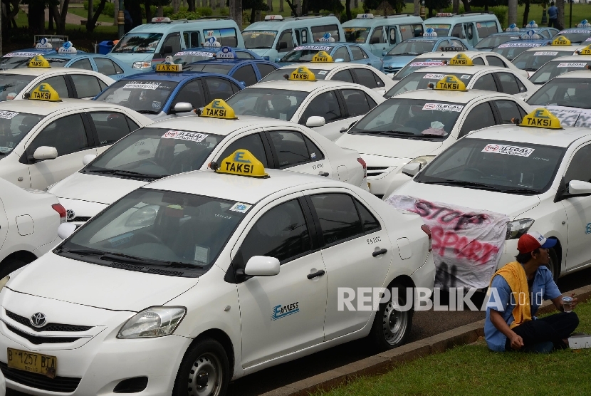 Angkutan umum diparkir di halaman Monas saat ribuan sopi melakukan aksi di depan Balai Kota DKI Jakarta, Senin (14/3). 