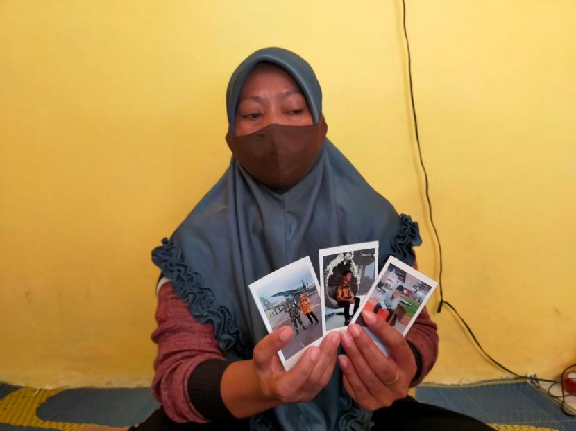 Ani (40 tahun), warga Kecamatan Sindangkasih, Kabupaten Ciamis, memegang foto anaknya yang meninggal dunia usai menjalani vaksinasi, Rabu (8/9).