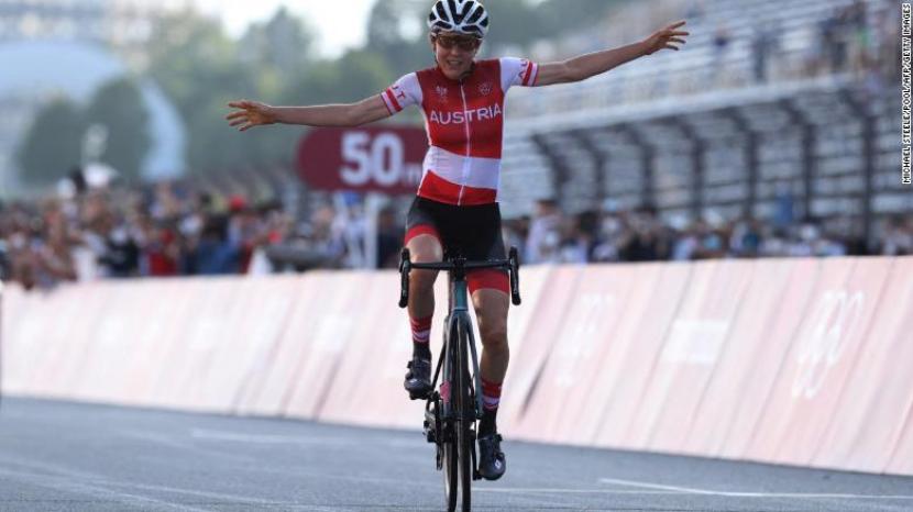 Anna Kiesenhofer melintasi garis finis untuk memenangkan balap sepeda wanita di jalan raya Olimpiade Tokyo pada hari Minggu.