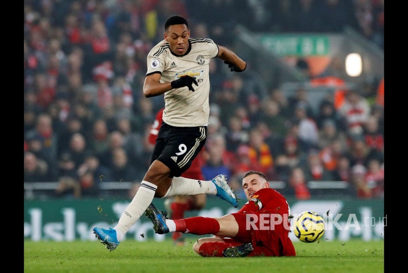 Anthony Martial melewati adangan Jordan Henderson pada laga Liverpool melawan Manchester United di Anfield Stadium, Liverpool, Senin (20/1) dini hari WIB.