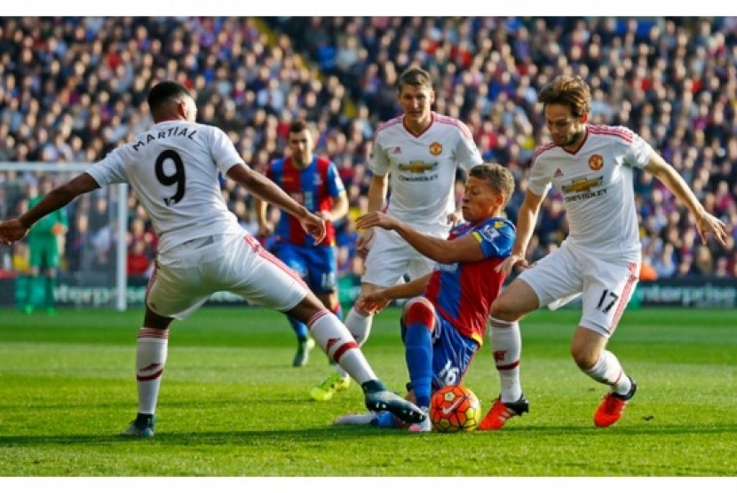 Anthony Martial (kiri) dan Daley Blind (kanan) berusaha merebut bola dari kaki pemain Crystal Palace Dwight Gayle.