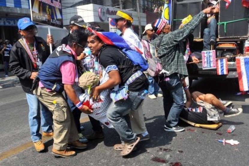 Anti-government protesters help a fellow protester injured in a grenade attack during a rally in Bangkok in this January 17, 2014.
