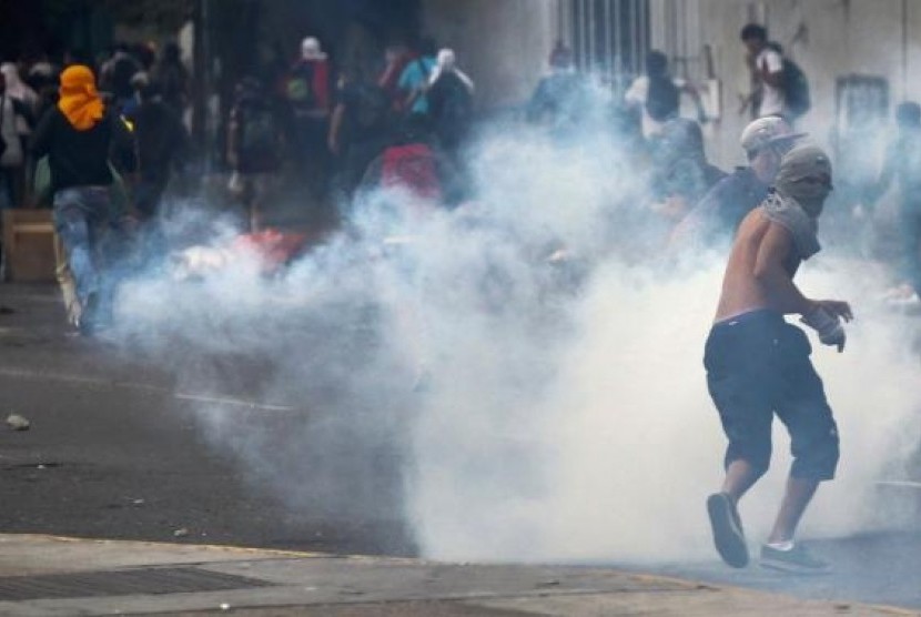 Anti-government protesters run from tear gas during a protest against Nicolas Maduro's government in Caracas March 13, 2014.