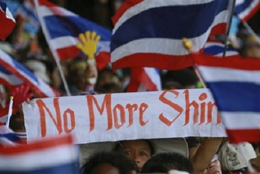 Anti-government protesters wave a banner and Thai national flags as they rally outside the Government complex in Bangkok, Thailand, Wednesday, Nov. 27, 2013.