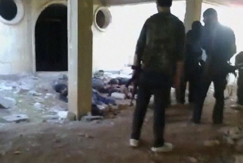 Anti-government rebels surround dead Syrian army soldiers after a shooting in this still image captured from amateur video footage released on a social media website, in Saraqeb November 1, 2012. The video that appears to show Syrian rebels killing soldier