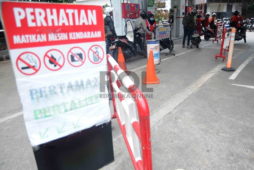  Antrean pengendara sepeda motor untuk mengisi BBM di Stasiun Pengisian Bahan Bakar Umum (SPBU) di Jakarta, Rabu (30/12). 