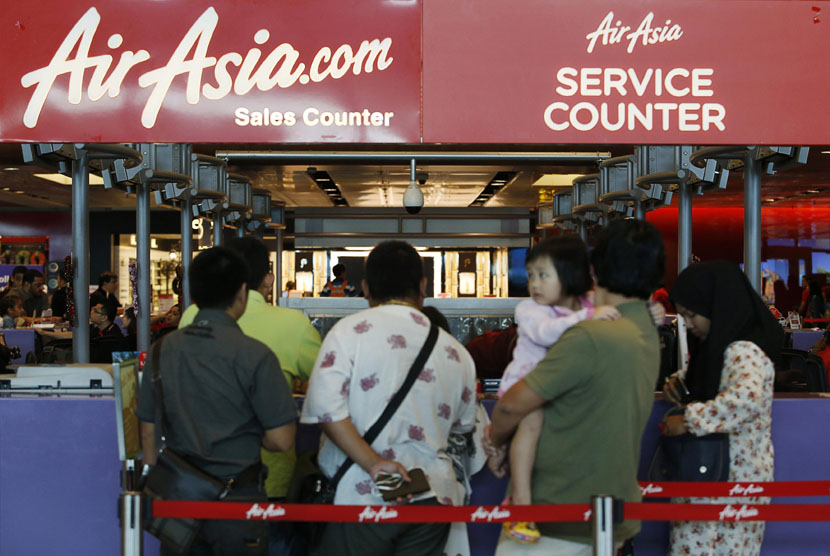   Antrean penumpang di konter Air Asia bandara Changi Singapura, Ahad (28/12). (Reuters/Edgar Su)