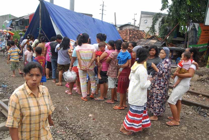 Antrean warga korban banjir di posko kesehatan kawasan Pasar Pesing, Kedoya Utara, Jakarta Barat, Rabu (15/1).    (Republika/Rakhmawaty La'lang)