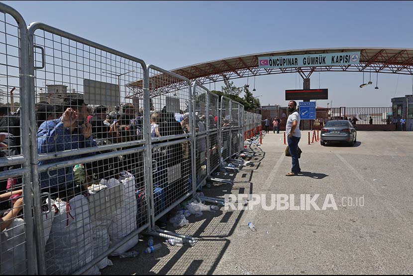 Antrean warga Suriah yang tinggal di Turki menunggu dibukanya pintu perbatasan dengan Suriah di dekat Kota Kilis, Turki.