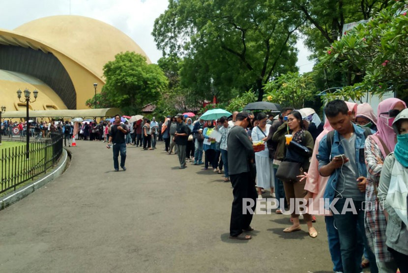 Warga mengantri untuk melakukan perekaman dan cetak e-KTP di lapangan parkir Teater Imax Keong Mas TMII, Jakarta, Jumat (20/10). 