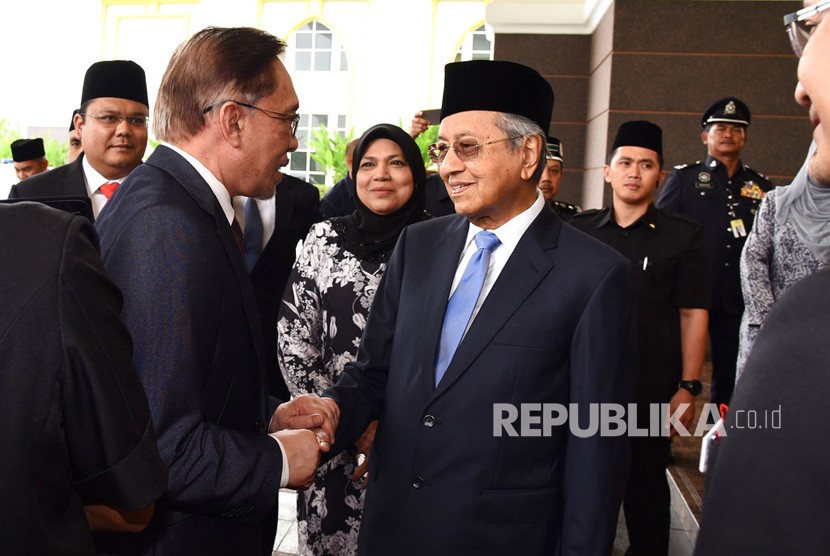  Anwar Ibrahim berjabat tangan dengan Mahathir Mohamad. 
