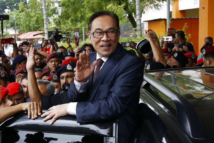 Anwar Ibrahim melambaikan tangan saat dinyatakan bebas seusai keluar dari rumah saki, Rabu (16/5).