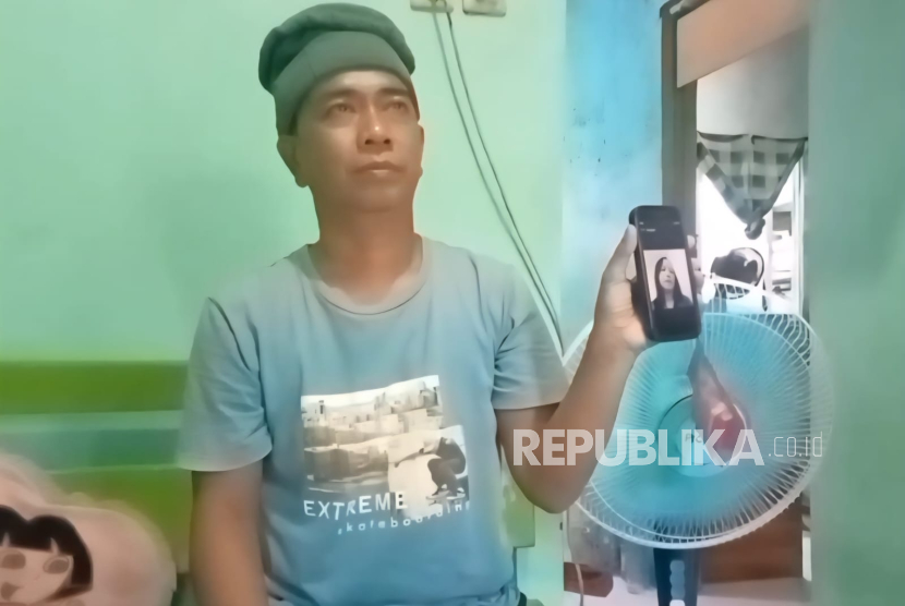 Apandi menunjukkan foto kakaknya, Tasmi (50), yang meninggal dunia akibat sakit saat bekerja sebagai TKW di Malaysia. Ia memohon bantuan pemeritnah untuk memulangkan jenazah kakaknya.