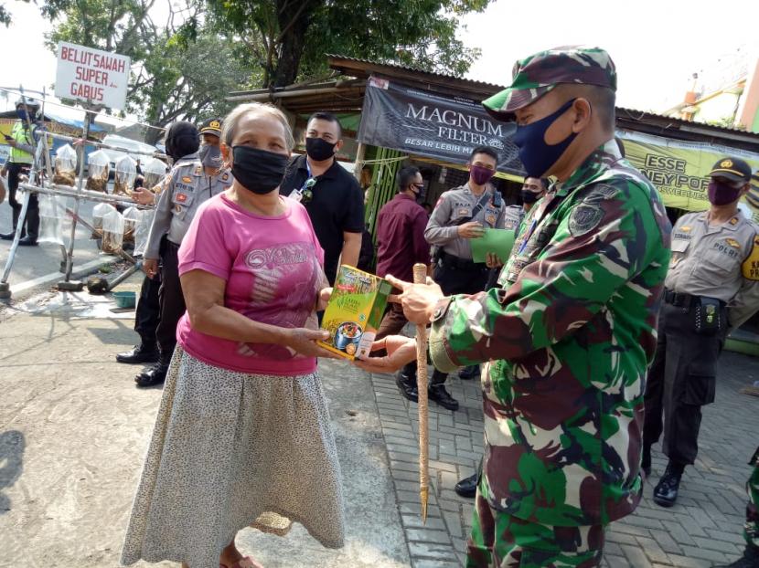 Aparat dan komunitas di Kabupaten Garut membagikan paket nasi liwet instan ke warga terdampak pandemi corona, Rabu (15/4).