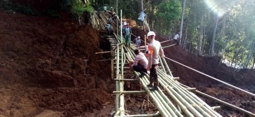 Aparat dibantu warga sekitar membuat jembatan darurat di Kampung Bugel, Desa Bugel, Kecamatan Ciawi, Kabupaten Tasikmalaya, Kamis (11/6). Sebelumnya, jembatan desa yang berada di lokasi itu putus tertimpa longsor pada Rabu (10/6).