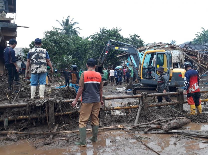 Aparat gabungan dan relawan masih berupaya mengevakuasi material dan kendaraan yang terdampak banjir bandang di Desa Pasawahan, Kecamatan Cicurug, Selasa (22/9)