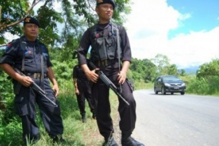 Aparat keamanan dari Sat Brimob Polda Papua berjaga di lokasi peristiwa penembakan yang dilakukan oleh orang tak dikenal yang menewaskan tiga warga sipil dan satu anggota TNI, di Kampung Nafri, Jayapura, Papua.