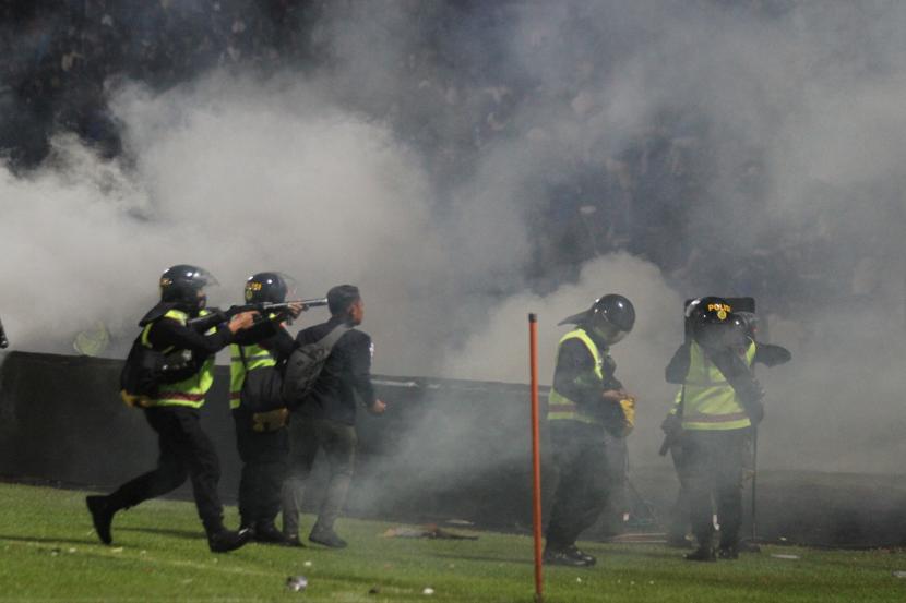 Polisi menembakkan gas air mata uke arah tribun usai pertandingan sepak bola BRI Liga 1 antara Arema melawan Persebaya di Stadion Kanjuruhan, Malang, Sabtu (1/10/2022) malam WIB.
