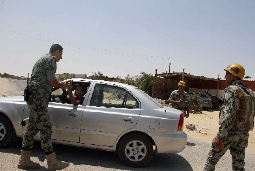 Aparat keamanan Mesir memeriksa kendaraan di dekat lokasi serangan di Semenanjung Sinai, dekat perbatasan Gaza.