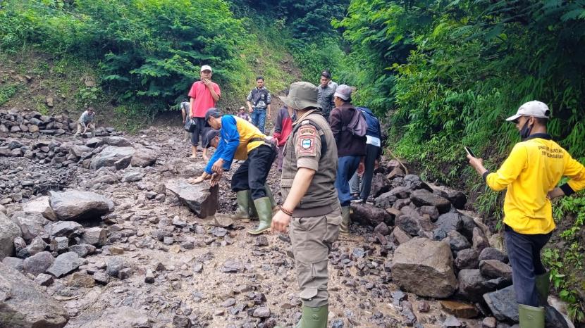 Aparat Kecamatan Talegong dan warga bahu membahu membersihkan salah satu ruas jalan yang tertimbun material longsor, di Kampung Ciwaru, Desa Sukamulya, Kecamatan Talegong, Kabupaten Garut, Jumat (5/10). 