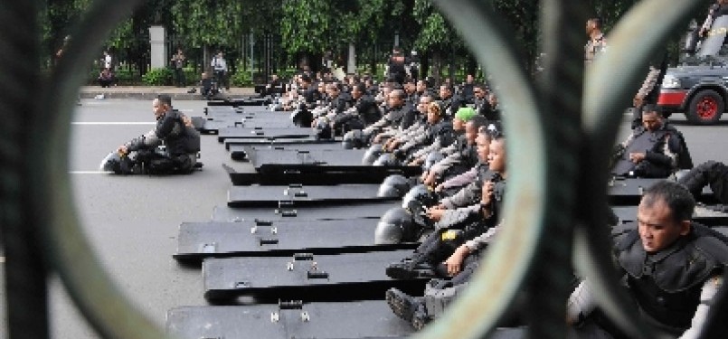 Aparat kepolisi duduk sambil siaga menunggu aksi demonstrasi mahasiswa menolak kenaikan harga BBM di Kawasan Monas, Jakarta, Selasa (27/3). 