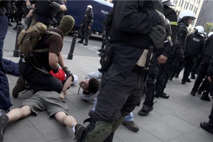 Aparat kepolisian anti-huru hara Polandia menahan suporter yang terlibat perkelahian di Piala Eropa 2012 Polandia-Ukraina. 