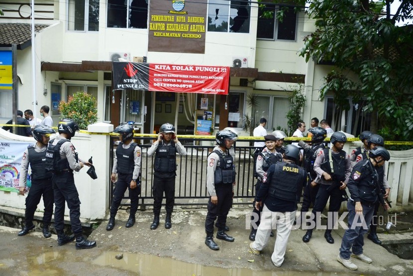 Aparat kepolisian bersenjata lengkap berjaga-jaga saat olah TKP terkait pelaku peledakan bom yang berhasil dilumpuhkan, di kantor kelurahan Arjuna , Kota Bandung, Senin (27/2).